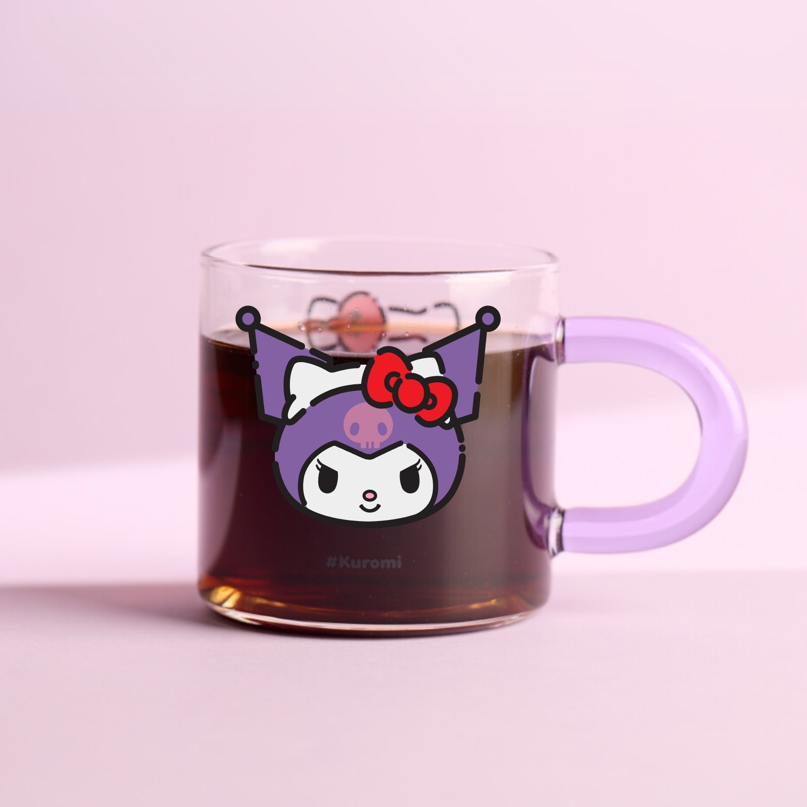 A glass mug with a Hello Kitty character design featuring a red bow on the front, complete with a blue handle.